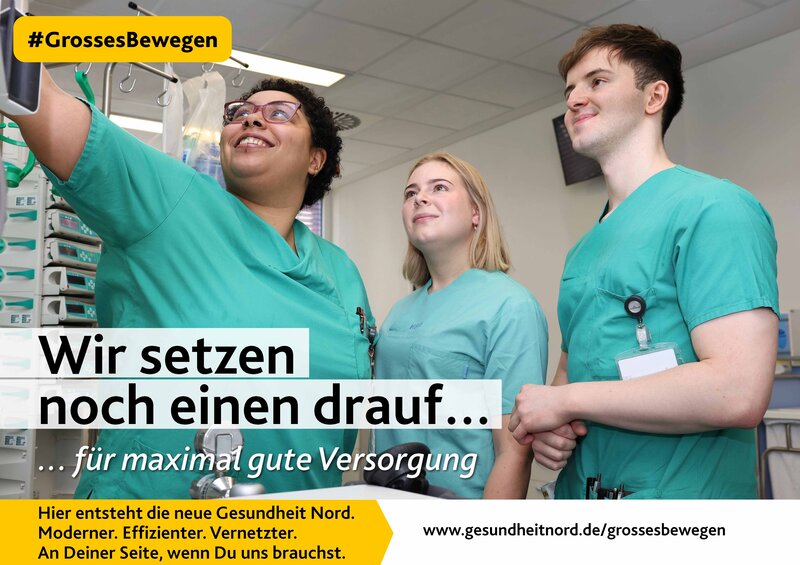 Drei Kolleginnen und Kollgegen in grüner Dienstkleidung schauen auf einen Monitor und der Text ist "Wir setzen noch einen drauf..."