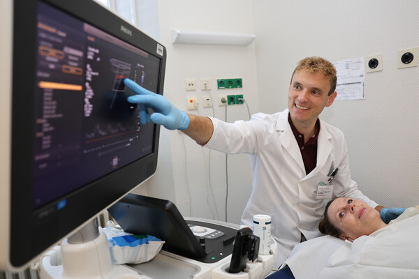 Dr. Christoph Kiehl zeigt einer Patientin etwas am Monitor