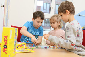 Drei Kinder spielen in einem Krankenhauszimmer ein Brettspiel