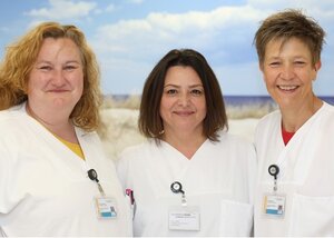 Gruppenbild von drei freundlichen Frauen in weißer Dienstkleidung