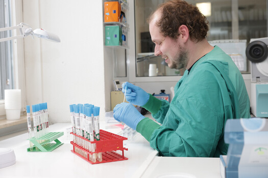 Foto eines Labormitarbeiters mit Proben